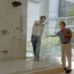 新業(yè)建設(shè)卓勝隆董事長(zhǎng)（右）伸手測(cè)試三段式水流變化為肌膚帶來的觸感，親身體驗(yàn)，精選出舒心的衛(wèi)浴設(shè)備。