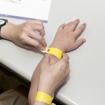 活動開始之前，工作人員協(xié)助大、小朋友們戴上分組的幸運手環(huán)。