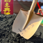 新業(yè)建設(shè) 穆椿松 創(chuàng)辦人 於金鏟上簽名留念，開(kāi)工誌慶，步步啟程。