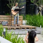 音樂家駐點表演，歌聲隨風飄散於市集中，使略微慵懶的週六下午增添些許閒適感。一旁被歌聲吸引而來的小妹妹，也開心地以手機紀錄這美好時光。