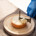 半硬質家族的修道士(TETE DE MOINE)，呈小型鼓狀，外殼有點油膩、呈褐色，乳酪團結實且濃郁，隨著熟成顏色會加深，以轉臺式乳酪削切器，削成花摺邊小花苞。