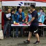 現(xiàn)場新業(yè)建設穆椿松名譽董事長（左二）與卓勝隆董事長（左一）引領(lǐng)大家，加油吶喊給予跑者支持。