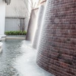 與接待大廳相對(duì)，僅隔一道玻璃落地窗即為「戶外水瀑牆」。流水潺潺與磚石沖刷出平整的紋路，水光相映下霧氣生騰，彷若仙境。－【新業(yè)觀峰】。