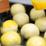 刷上蛋黃液，點(diǎn)上芝麻裝飾，圓潤蓬鬆的蛋黃酥即將穿上金黃酥脆的外衣。