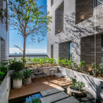 四季合院，每三層設(shè)計(jì)一處公共大露臺(tái)，從梯廳走入彷彿大家庭的合院(埕)，提供住戶(hù)們休憩及交誼空間，搭配四季主題的呼應(yīng)，此為七樓的夏季-種植小花紫薇與厚葉石斑木。