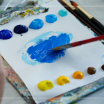 飽和多彩的顏料，在紙製調(diào)色盤上，用畫筆輕輕均勻塗開，準備在素色畫布上恣意揮灑。