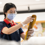 將粽葉的光滑面向內，粗糙面向外，糯米較不會黏粽葉，擇兩片將蒂頭端與尾端交疊。