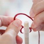 引線、綁結(jié)，將喜氣洋洋的紅線固定在燈籠之上，已完成吊掛的功能。