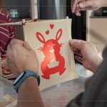 剛完成的剪紙，辛卯喜兔浮躍紙上，手捧著元寶寓意財(cái)源滾滾，家族發(fā)揮創(chuàng)意增添
兩顆小愛心，俏皮且生動(dòng)的趣味十足。