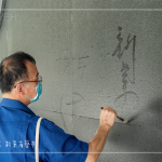 位處一隅的墨痕詩牆，開放大朋友與小朋友提筆、沾水，於黝黑的牆面體會親手落筆書寫的美好。