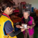 「阿嬤呷飯囉!」，甘霖基金會志工將便當送到獨居長輩手中的同時，也不忘送上一兩句暖心的問候。