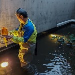 新業(yè)職人將雙足浸入水裡，測試不同高低與角度的琉璃燈光效果，只為選出最貼近完美的建築表情。