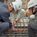 由新業(yè)建設名譽董事長穆椿松先生（圖左一）、卓勝隆董事長（圖右一）一同親手將主角「噴金漆鋼筋」綁紮、安置於屋頂中樑位置，代表著建築的穩(wěn)定與安詳。